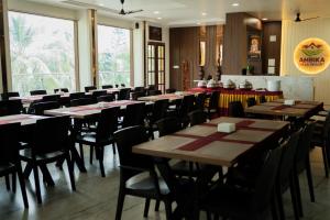 a restaurant with tables and chairs in a room at Ambika Hills Resort in Junnar