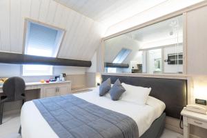 Un dormitorio con una cama, un escritorio y un espejo. en Hotel Croce Bianca, en Asiago