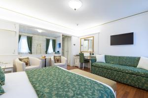 1 dormitorio con cama, sofá y sala de estar en Hotel Croce Bianca, en Asiago