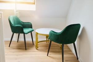 due sedie verdi e un tavolo in una stanza di ImoX a Wuppertal