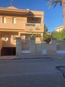 una casa grande con una valla y una palmera en Casa Del Mar, en Calabardina