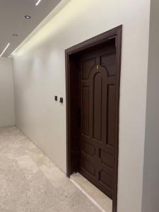 eine dunkelbraune Tür in einem weißen Raum in der Unterkunft comfortable hotel Jeddah in Dschidda