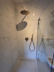 Un baño con ducha, inodoro y lavabo. en B&B Lindehoeve Texel, en Den Hoorn