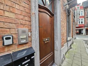 Maison Mimosa avec garage privé في دينانت: باب على جانب مبنى من الطوب