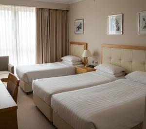 a hotel room with two beds and a window at Görgülü Apart 06 in Mamak +16 photos