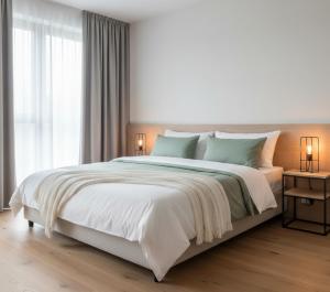 a white bedroom with a large bed with two lamps at Görgülü Apart 06 in Mamak