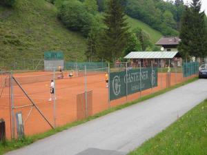 una pista de tenis con gente jugando en la pista en Appartements Hartlbauer, en Dorfgastein