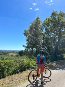 a man walking a bike down a road at Mas de Veyras - Gîtes 5 étoiles en Ardèche in Lachapelle Sous Aubenas