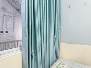 een groen gordijn in een kamer met een toetsenbord bij Đồng Xanh 502NK in Hanoi