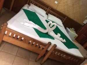 ein Bett mit einer grünen und weißen Decke drauf in der Unterkunft Yamawa Guesthouse Trang ยามาวา เกสเฮาส์ in Trang