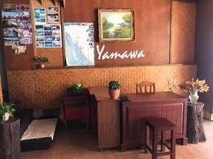 ein Restaurant mit einer Bank, einem Tisch und Stühlen in der Unterkunft Yamawa Guesthouse Trang ยามาวา เกสเฮาส์ in Trang