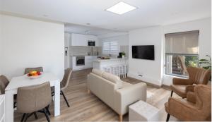 a kitchen and living room with a table and chairs at Coastal Views - waterfront guest apartment in Daleys Point