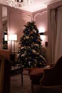 فندق لانكاستر باريس شانزليزيه في باريس: شجرة عيد الميلاد جالسة في غرفة معيشة مع