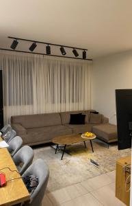 un salon avec un canapé et une table dans l'établissement דירה חמה ונעימה לשומרי מסורת, à Modiin