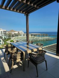 a table and chairs on a balcony with a view of the ocean at 4 Bedroom Suite Building-Wide Balcony Fujairah in Fujairah +18 photos