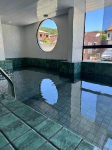 a pool in a house with a circular window at Hotel Estrela do Mar in Penha