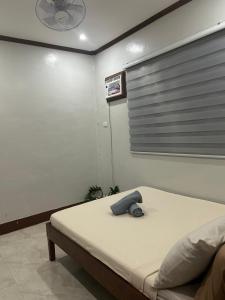 a bedroom with a bed with a clock on the wall at Sinta Stay in El Nido +2 photos