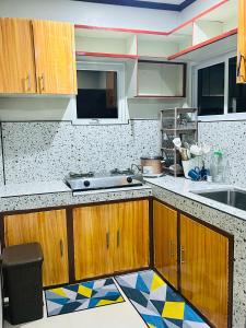 a kitchen with wooden cabinets and a mosaic floor at Sinta Stay in El Nido
