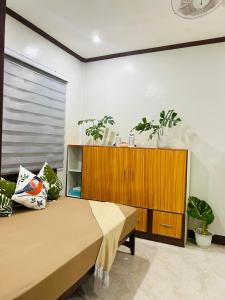 a bedroom with a bed and a wooden cabinet at Sinta Stay in El Nido