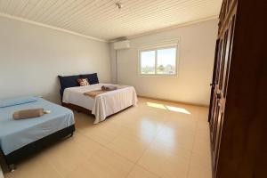 a bedroom with two beds and a window at Sobrado de 3 quartos in Capão da Canoa +8 photos