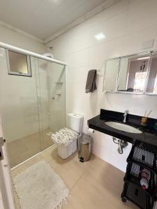 a bathroom with a shower and a sink and a toilet at Sobrado de 3 quartos in Capão da Canoa