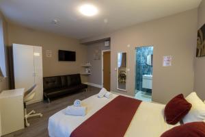 a hotel room with a bed and a couch at Paragraph Tottenham in Southgate