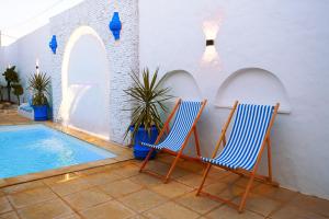 two chairs sitting next to a swimming pool at Dar Ayline in Erriadh