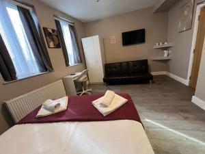 a room with a bed with towels on it at Paragraph Tottenham in Southgate +162 photos