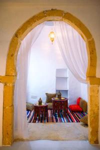 an archway with two tables in a room at Dar Ayline in Erriadh +27 photos