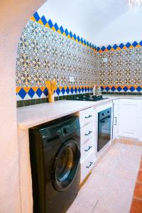 a kitchen with a washing machine in a kitchen at Dar Ayline in Erriadh