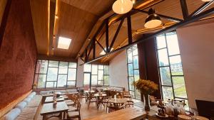 een restaurant met tafels en stoelen en grote ramen bij The Himalayan Tyangboche in Lukla