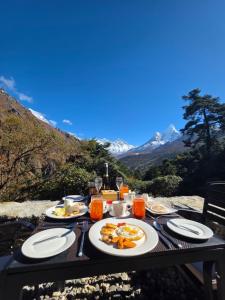 The Himalayan Tyangboche في Lukla: طاولة عليها صحون طعام مع جبال +41 صورة