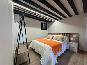 a bedroom with a large bed with an orange blanket at Casa Cuartel in Redondela