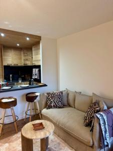 a living room with a couch and a kitchen at LiHam Alpine Suite in Megève +24 photos