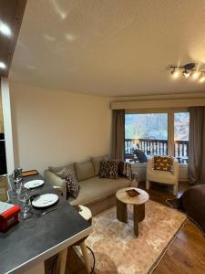 een woonkamer met een bank en een tafel bij LiHam Alpine Suite in Megève