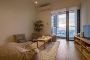 a bedroom with a bed and a living room with a tv at Studio Diane in Permatang Pauh