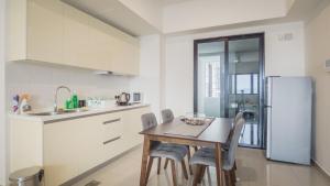 a kitchen with a table and chairs and a refrigerator at Studio Diane in Permatang Pauh
