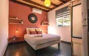 Le Verger Mandarine - Piscine & Spa a l'Entre-Deux في إنتري-ديو: غرفة نوم بجدران برتقالية وسرير مع نافذة