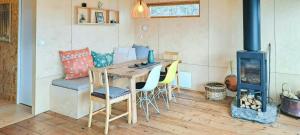 a kitchen with a wooden table and a wood stove at Self-Built Cabin With Views Over Leirvik in Leirvik