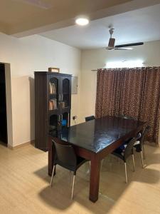 a dining room table with chairs and a book shelf at Ironwood Villa in Cochin