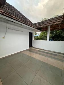 an empty garage with a white wall and a roof at Ironwood Villa in Cochin