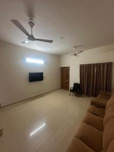a living room with a couch and a flat screen tv at Ironwood Villa in Cochin