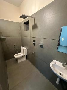 a bathroom with a toilet and a sink at Ironwood Villa in Cochin +6 photos