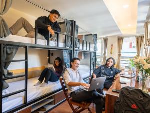 甘托克Moustache Hostel Gangtok的一群人坐在一个配有双层床的房间