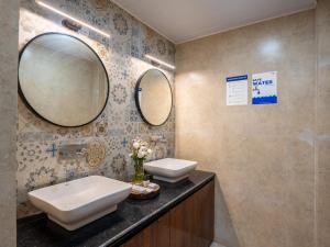 a bathroom with two mirrors and a sink at Moustache Hostel Gangtok in Gangtok