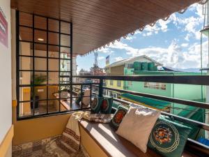 a balcony with pillows and a view of a building at Moustache Hostel Gangtok in Gangtok