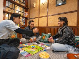 甘托克Moustache Hostel Gangtok的一群坐在地上玩游戏的人