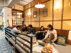 甘托克Moustache Hostel Gangtok的一群人围坐在房间里的一张桌子旁