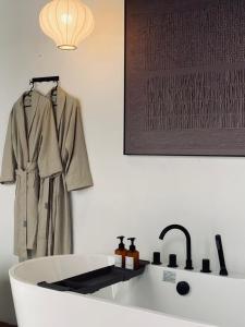 a coat hanging on a wall next to a bath tub at Heritage Villa by Aayu - 10 mins walk to Armenian St in George Town