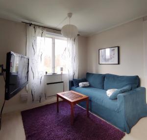 Una sala de estar con un sofá azul y una mesa. en Small Cottage, en Jönköping 9 fotos más
